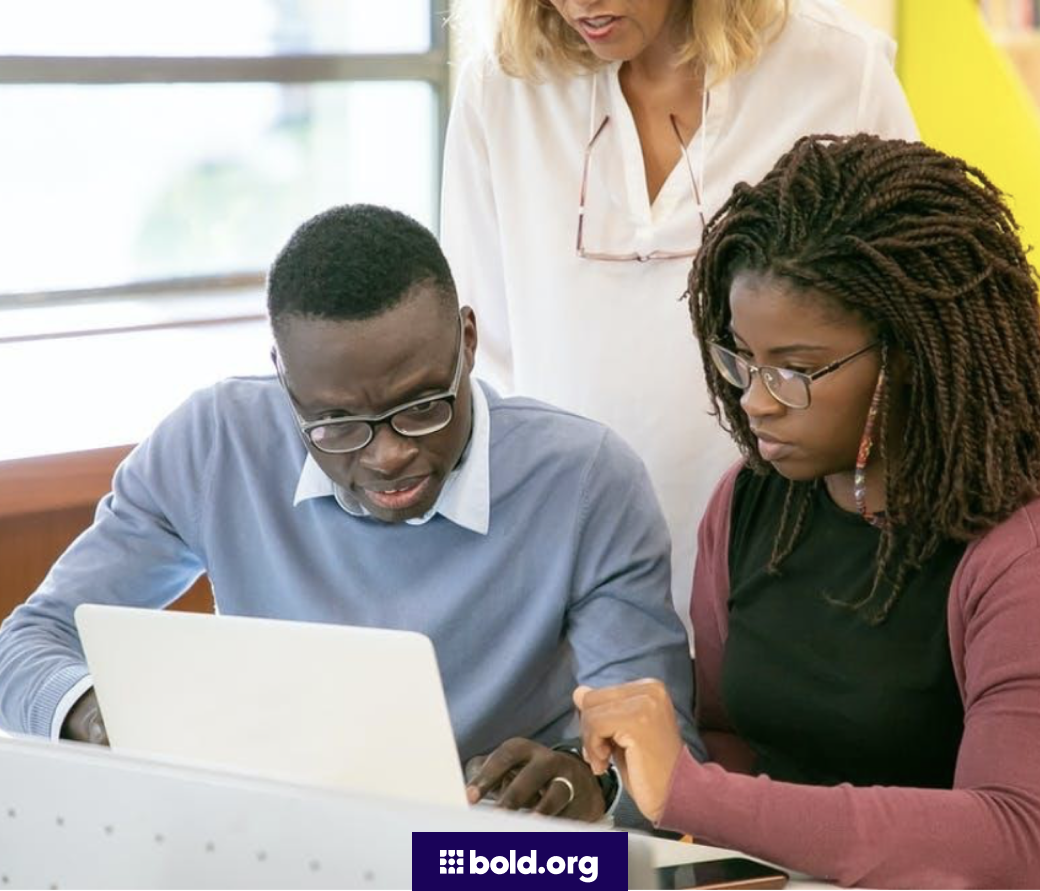 Three people looking at a laptop