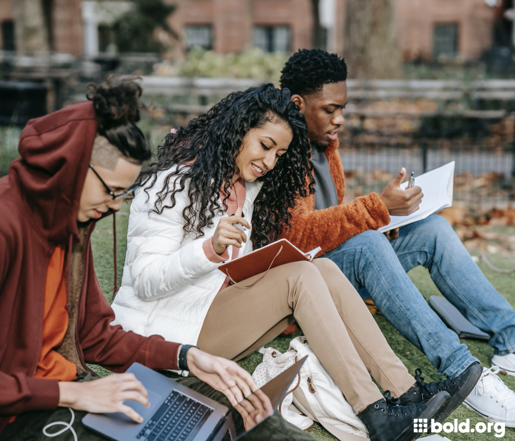 Three students studying together on the lawn