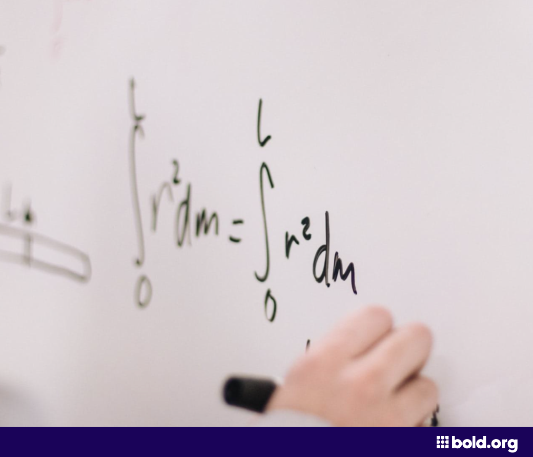 Person writing an equation on a whiteboard