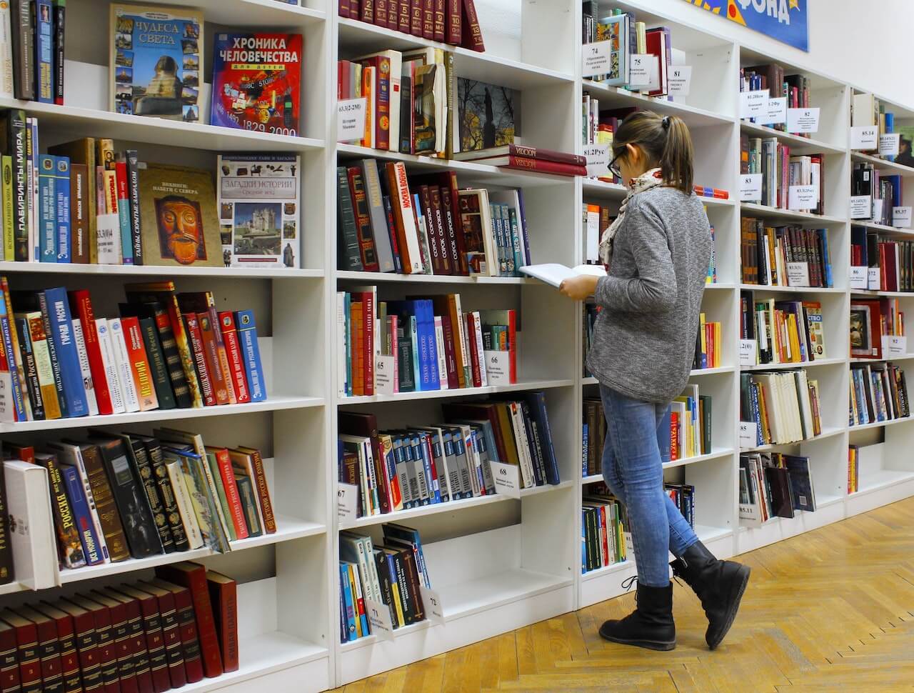 Student browsing through books in the library