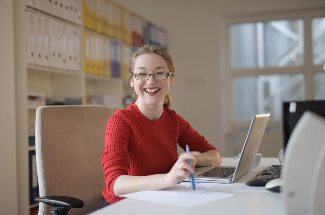 student smiling while sitting at desk