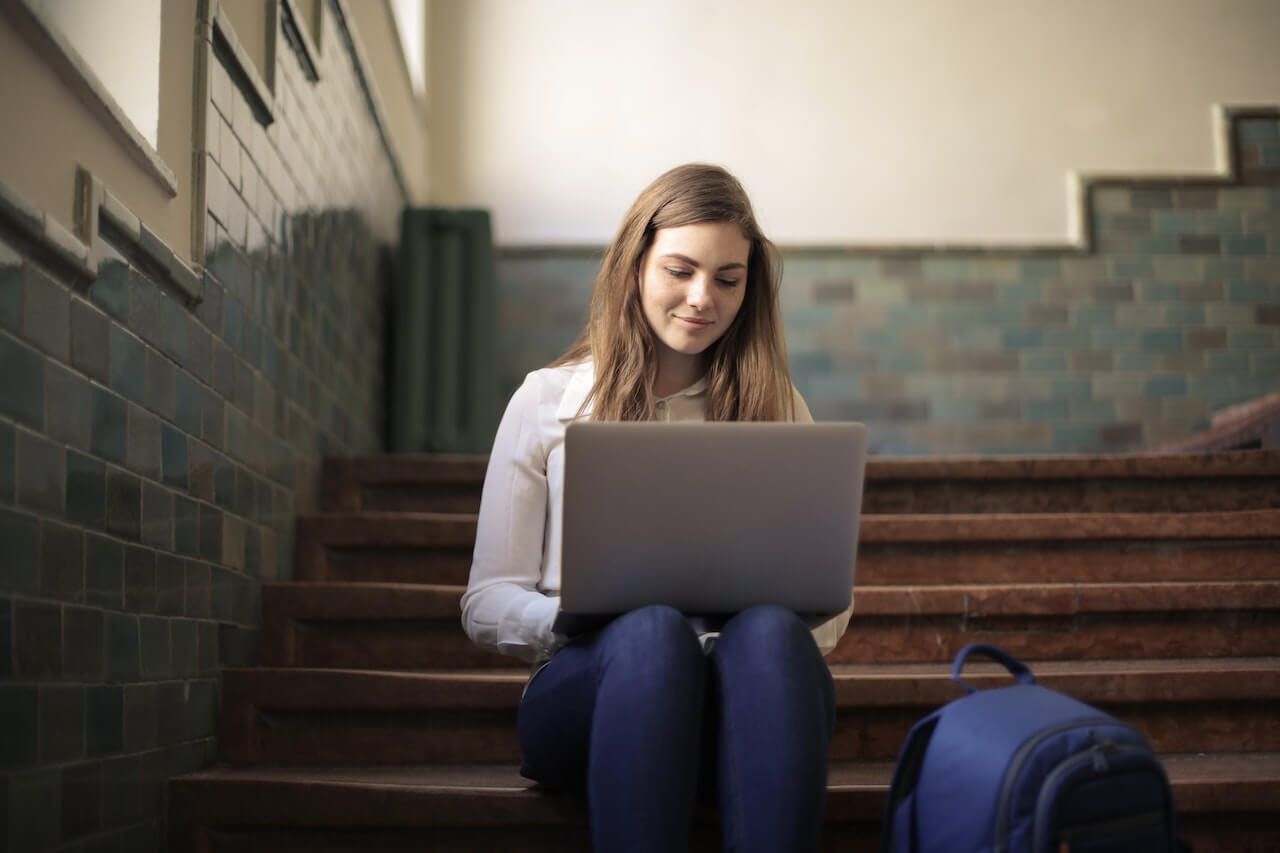 student typing on laptop