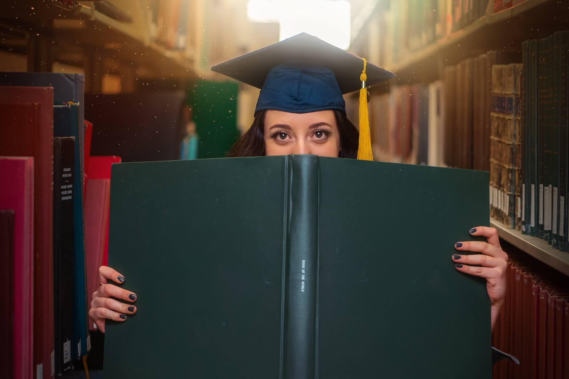 grad student wearing grad cap holding a book