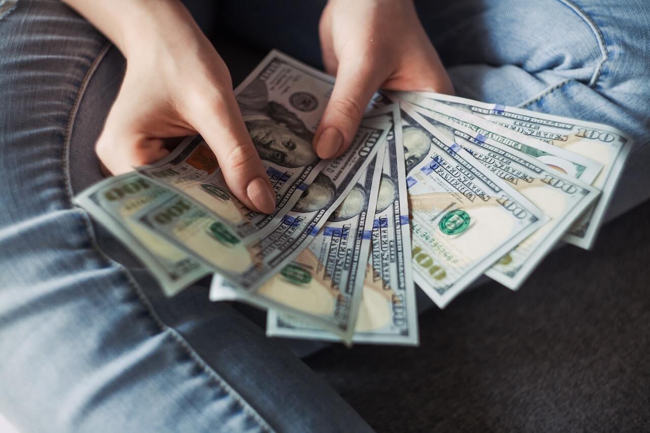 Student holding hundred dollar bills