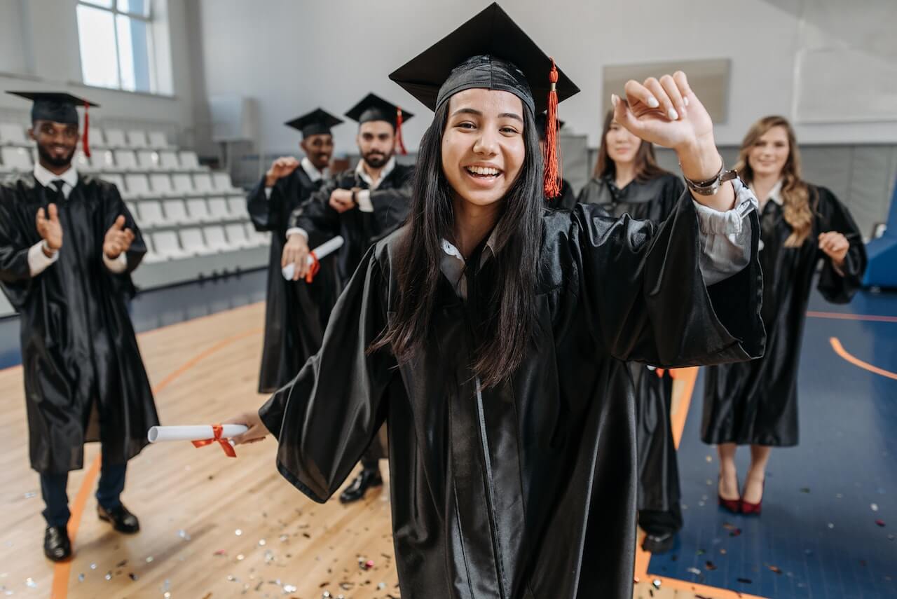 Group of students in graduation caps and gowns with diplomas