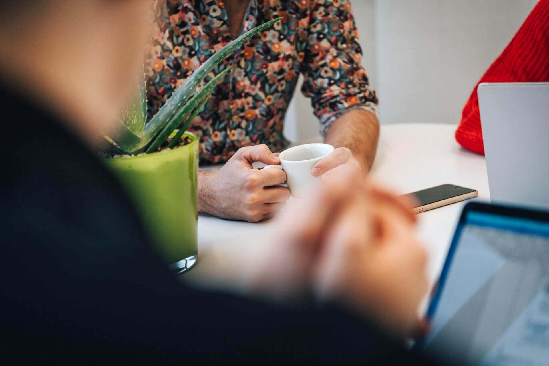 Three people have a meeting around a table.