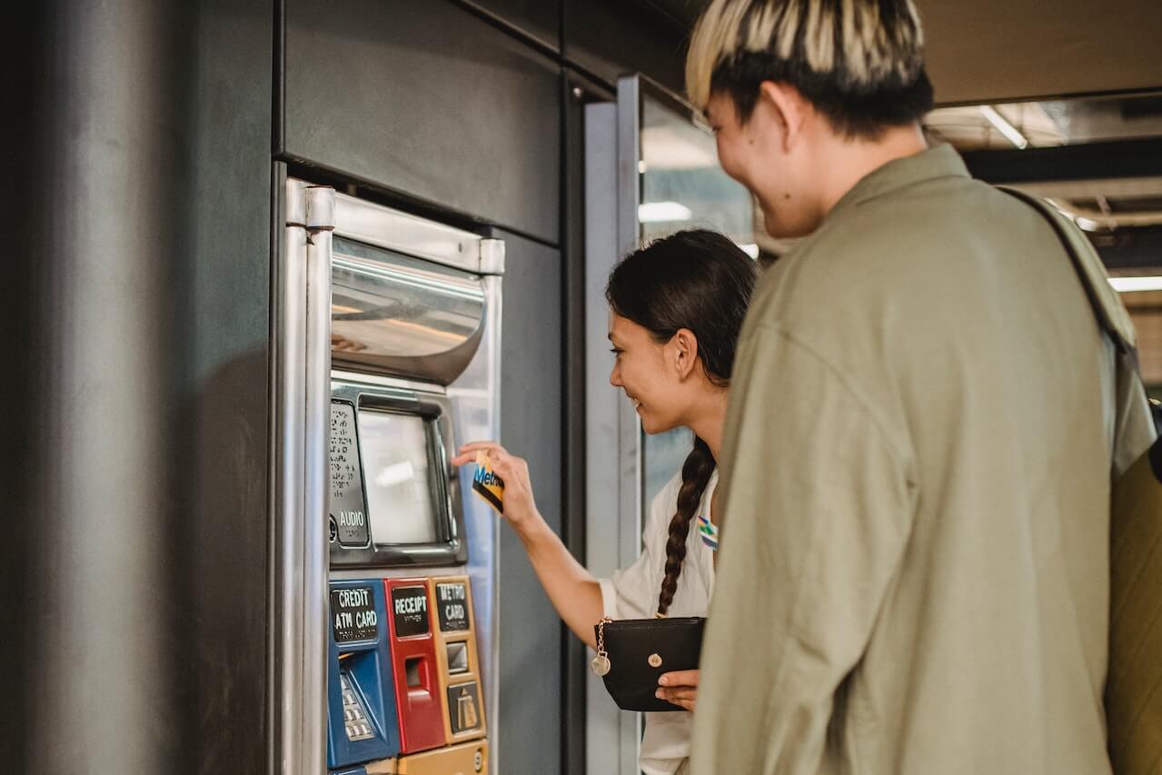 a man and woman using an ATM machine