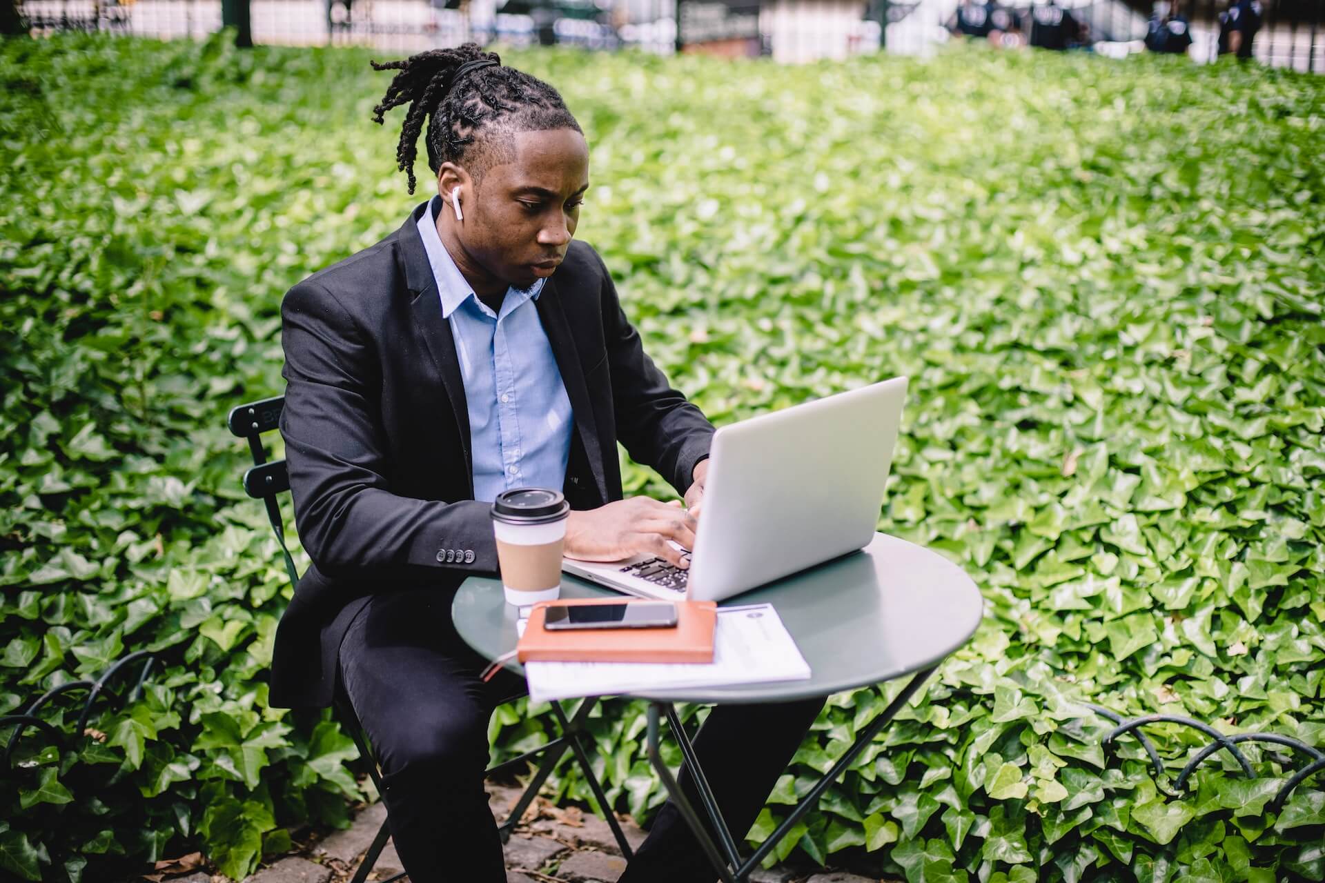 Student sitting at a table outdoors and typing on a computer