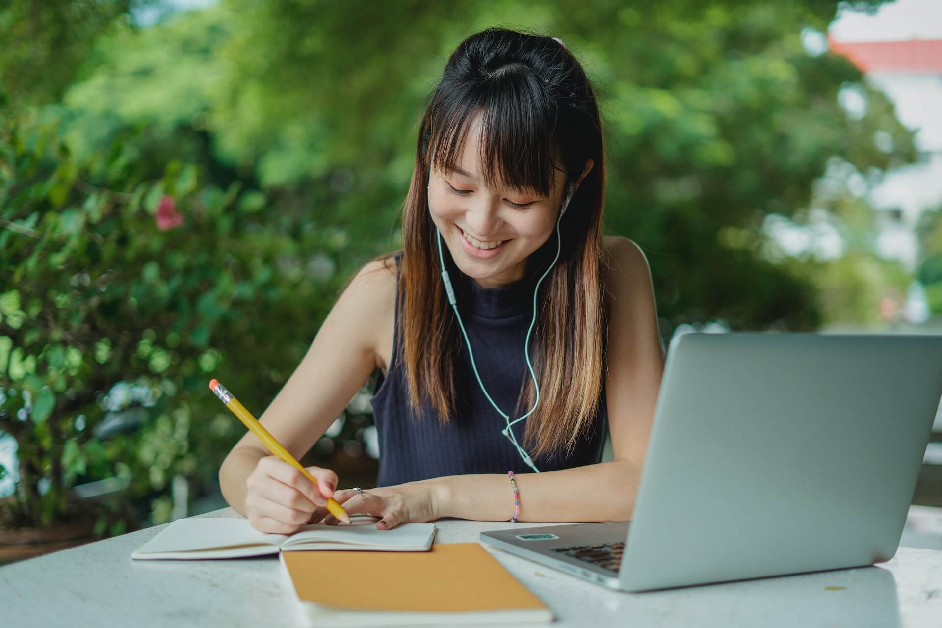 Student outlining an essay at a table outside