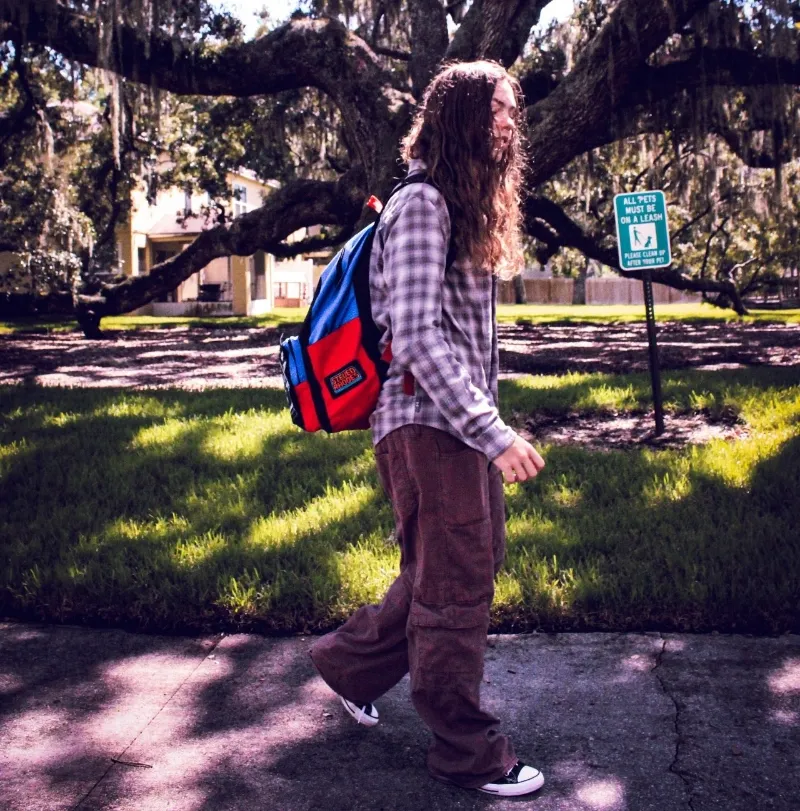 student walks to class on college campus