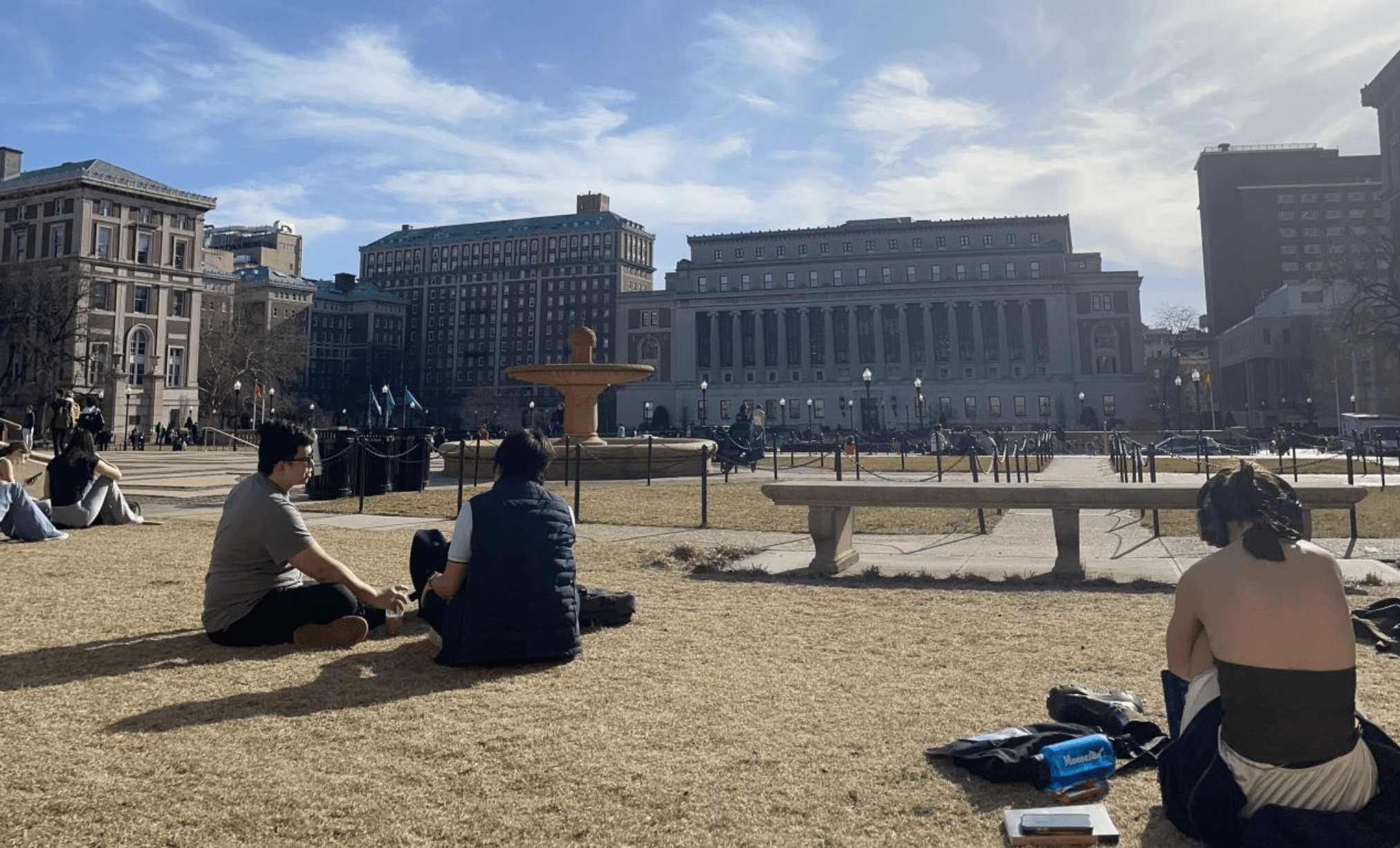 graduate students sit in campus courtyard