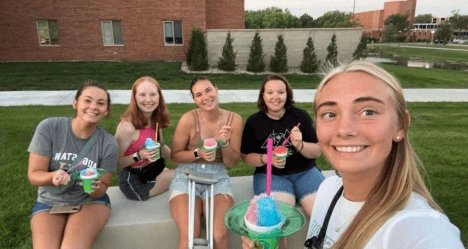 female college students eating snow cones on campus