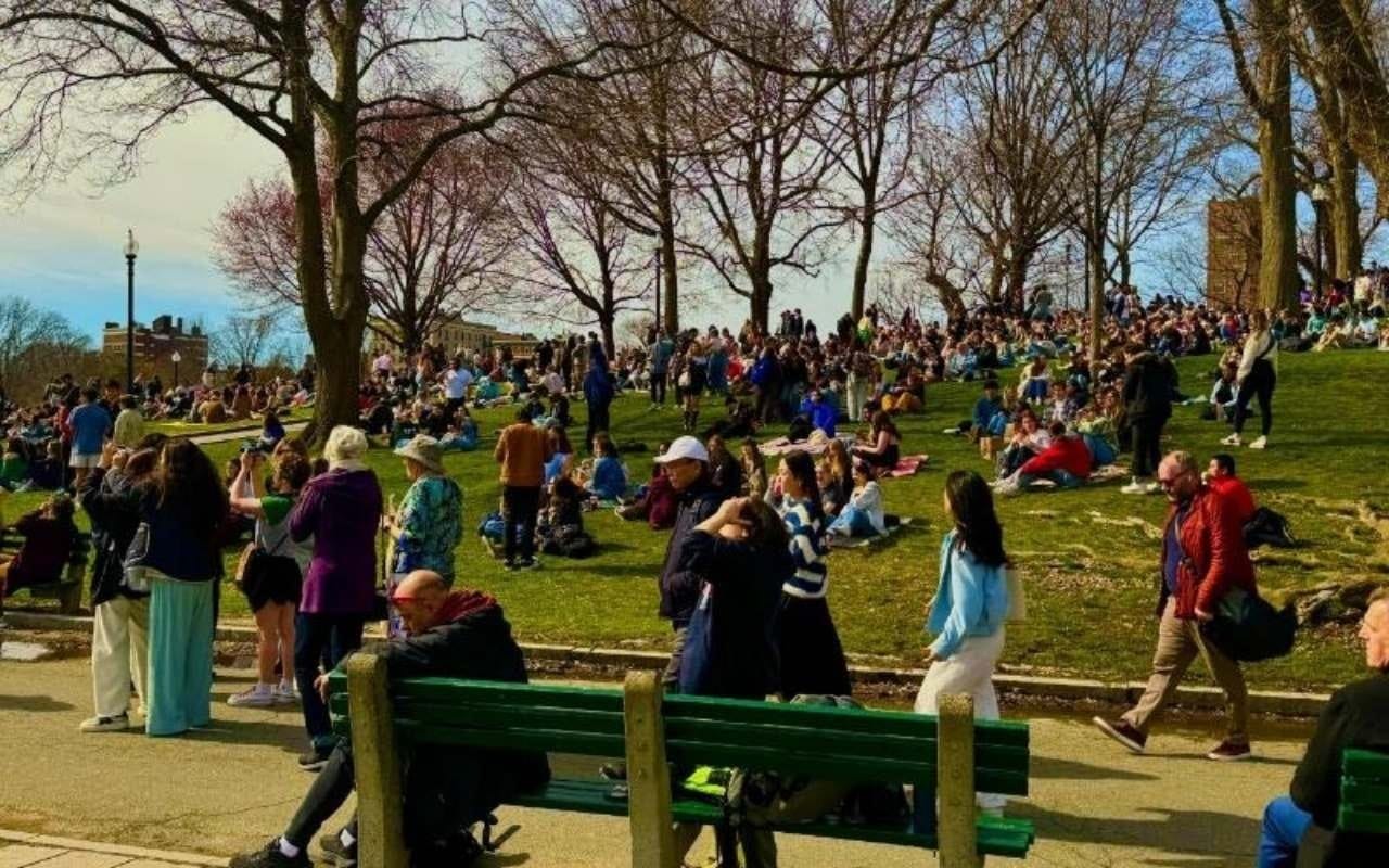 college students walking and picnicking on campus quad