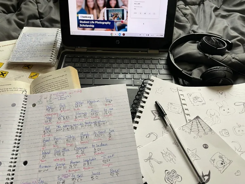 student's notes and doodles in front of laptop