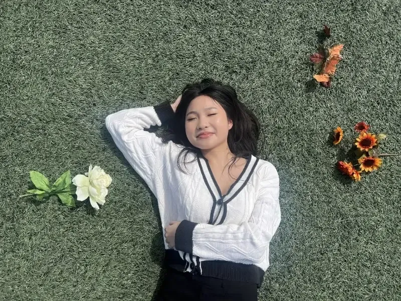 graduate student lies in grass field