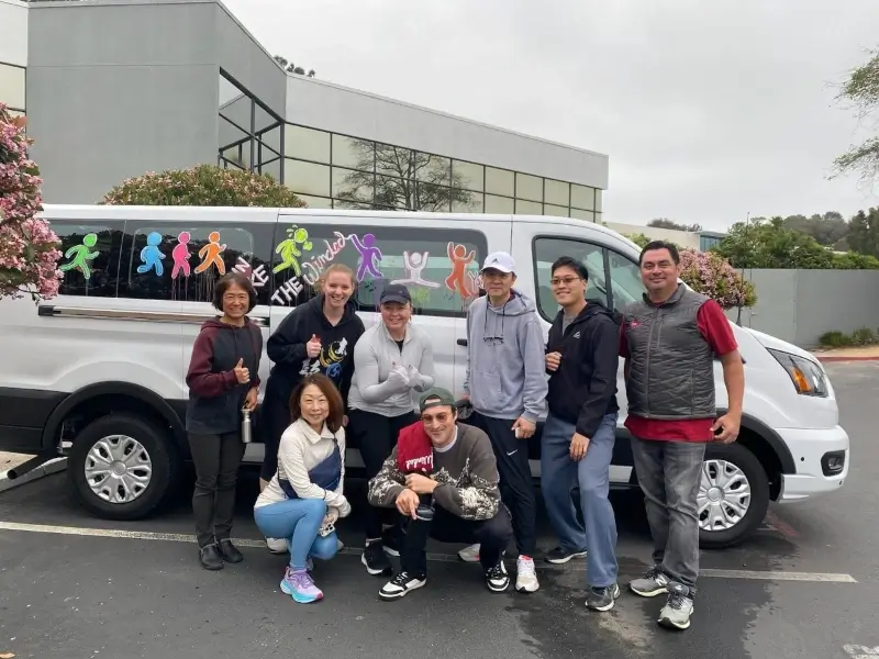 group of undergraduate students in front of a van