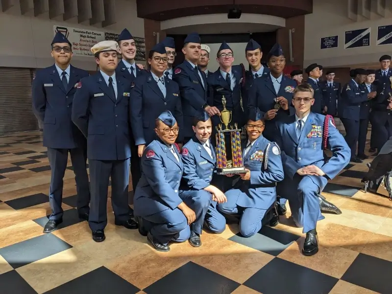 marine corps students pose with trophy