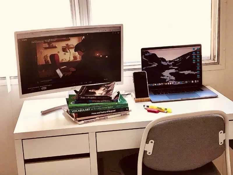 student's desk with textbooks and monitor