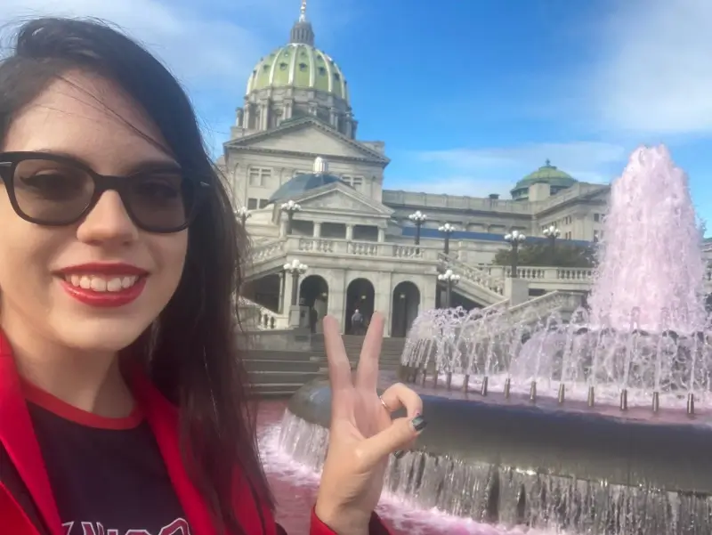 woman takes picture in front of government building