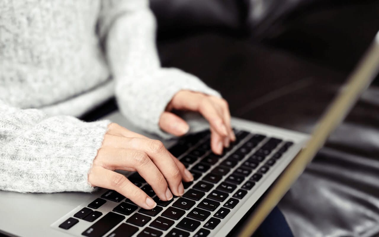 student typing on laptop