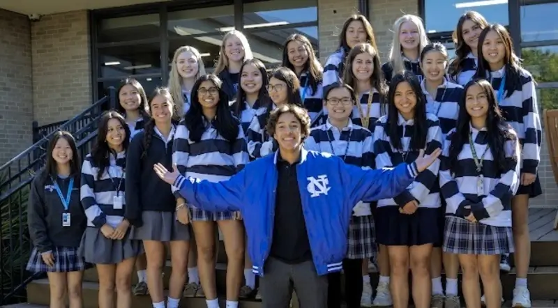 students in blue striped uniforms take senior class picture